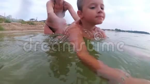 妈妈教孩子在河里游泳视频的预览图