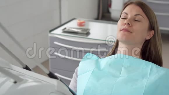 牙科诊所的女病人在牙科椅上等口腔医生牙科检查视频的预览图