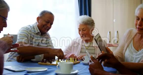 老年人在下棋时使用手机和数码平板电脑视频的预览图