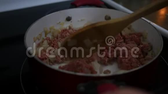 烤熟的土耳其肉放在炉子上的红锅里加洋葱千层面准备视频的预览图