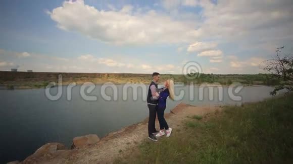 年轻夫妇在湖边接吻和拥抱视频的预览图