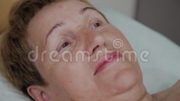 一位老年妇女躺在美容诊所的沙发上视频的预览图