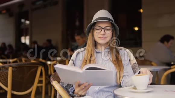 女孩在咖啡时间阅读书籍视频的预览图