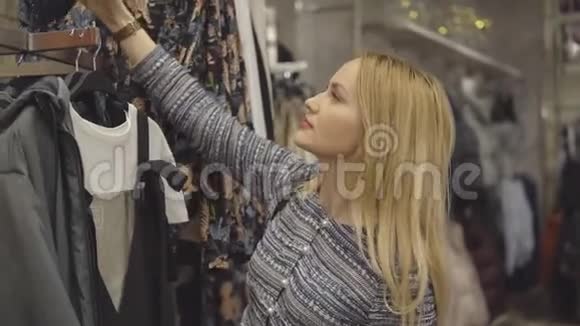 一个在百货公司挑选礼服的女孩的特写视频的预览图