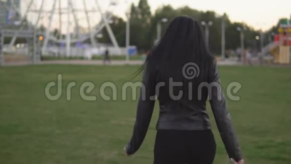 年轻女孩在阳光明媚的夏日公园的背景下跑来跑去视频的预览图