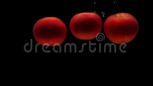 三个红色的假名在黑色的背景下落入透明的水中视频的预览图
