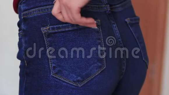 女人的手伸进屁股上牛仔裤的口袋视频的预览图