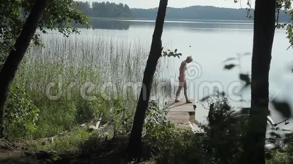 女人在湖上放松站在木墩边上视频的预览图