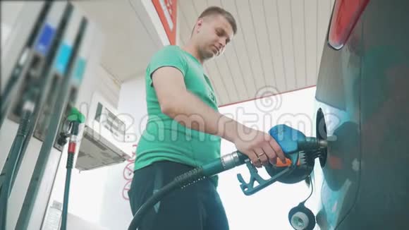 旧加油站那个人在车里倒汽油汽油被倒入汽车黑色汽车软管的生活方式视频的预览图