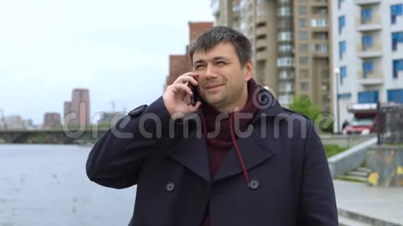 一个男人在城市景观的背景下用手机说话视频的预览图