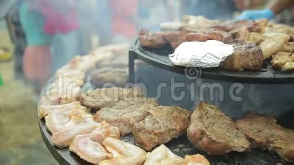 美味的肉鱼和香肠都是在一个大圆烤架上烤的视频的预览图