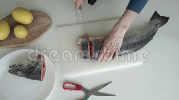女人在厨房里用刀切鱼顶部视图视频的预览图