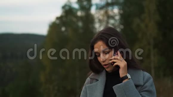 在公园附近用手机说话的女人视频的预览图
