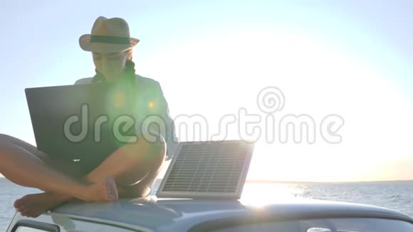 太阳能女性坐在老式汽车上在阳光下背景天空上有笔记本和电池女孩坐在屋顶上视频的预览图