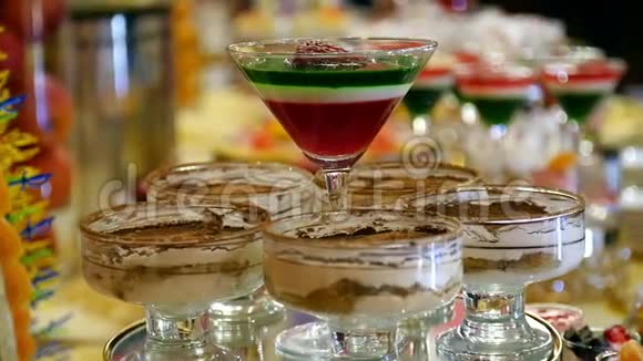 五颜六色的甜盘水果甜点果冻和蛋奶酥在玻璃里婚礼庆祝晚餐食物设计幻灯片运动视频的预览图