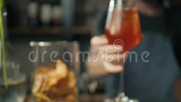 AperolSpritz鸡尾酒加橙片和冰块放在黑色托盘上庆祝杯子上放水滴酒保视频的预览图