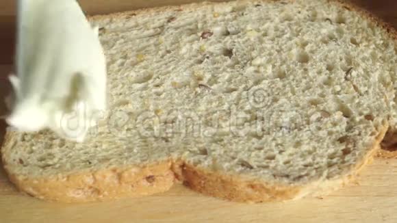 特写视频将奶油黄油涂在一块面包上视频的预览图