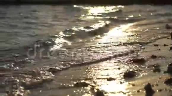 夜晚的海浪在夏日夕阳的照耀下闪耀一个美丽的夜晚在水中视频的预览图