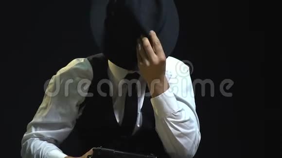 这位疯狂的侦探正在用一顶黑色帽子在镜头前做鬼脸来掩饰他的脸视频的预览图