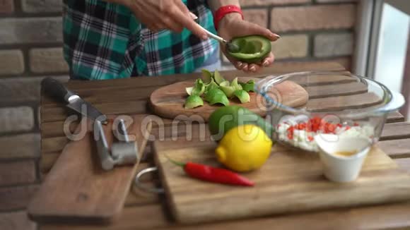 在家庭厨房的餐桌上女性用手切鳄梨做鳄梨酱视频的预览图