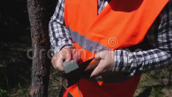 林业工人检查斧头的锋利程度视频的预览图