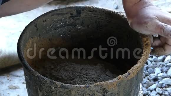 人们用沙子把水泥放进铁桶里得到一个灰泥视频的预览图