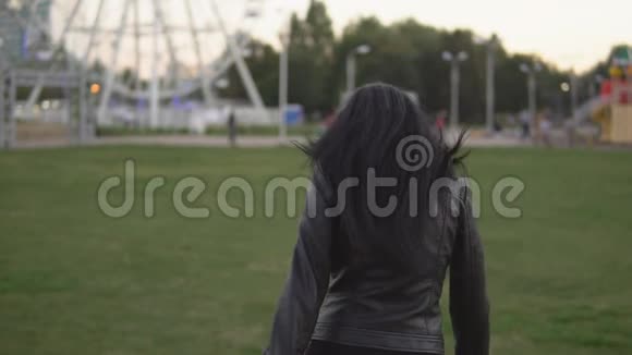 年轻漂亮的女人在阳光明媚的夏日公园里跑来跑去视频的预览图