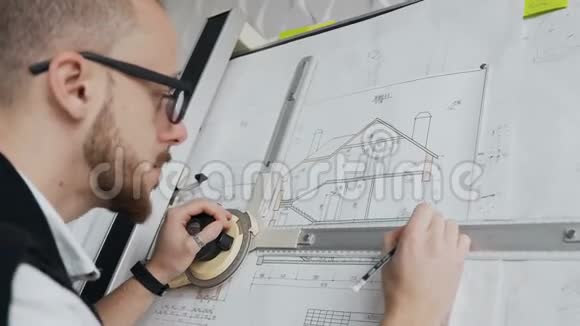 一位留着胡子戴着眼镜的男建筑师的特写镜头正在进行一个住宅建筑项目视频的预览图