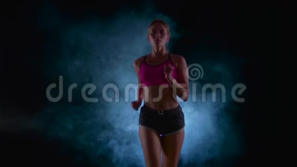 跑步运动女孩前景烟雾中的黑色屏幕慢动作视频的预览图