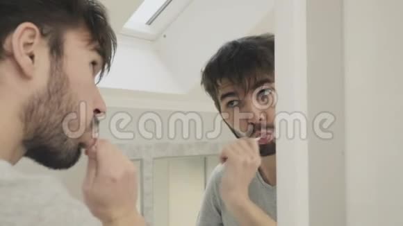 睡觉的人在镜子前清洁牙齿视频的预览图