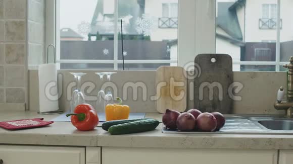穿围裙的人在厨房的水槽里洗蔬菜视频的预览图