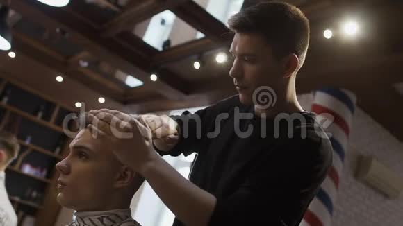 职业发型师为理发店的年轻人做发型视频的预览图