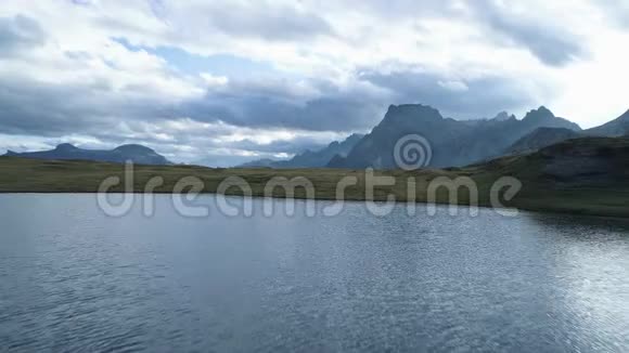 在多云的白天黄昏或黎明时高山湖上方的空中向后倾斜露出山谷欧洲意大利阿尔卑斯山视频的预览图