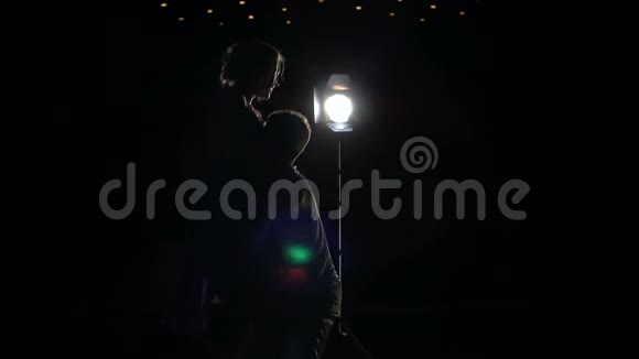 舞者在黑暗中在舞台上旋转的剪影视频的预览图