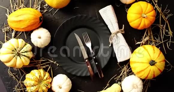 黑色的盘子被黄色的南瓜包围视频的预览图