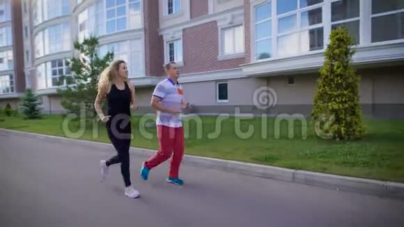 男性和女性跑步者在城市的街道上慢跑视频的预览图