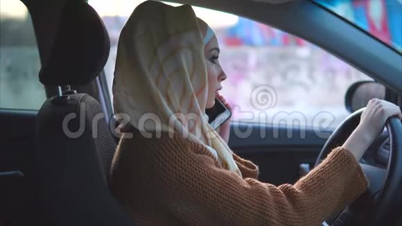 穆斯林妇女在城里开车她用手机视频的预览图