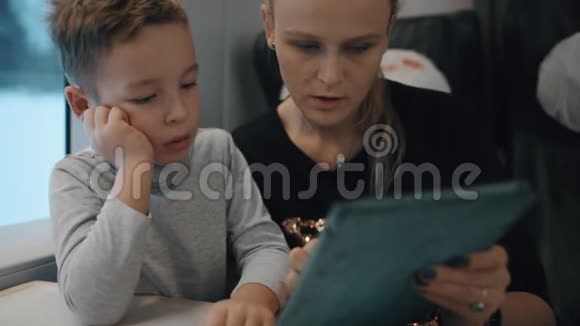 妈妈和儿子在火车上玩视频的预览图