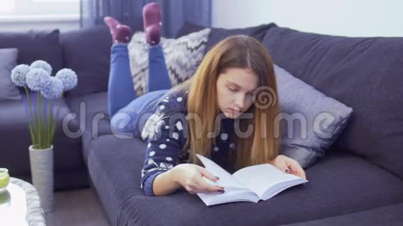 年轻漂亮的女孩躺在沙发上家里有书视频的预览图