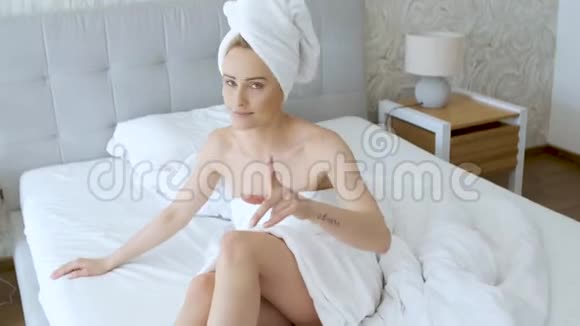 美丽的中年金发女人裹着毛巾白色毛巾视频的预览图