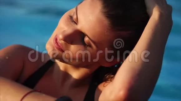 女孩子湿发在泳池碧水上的肖像视频的预览图