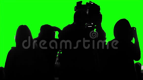 一群摄影师记者摄影师在绿色的屏幕上拍摄视频的预览图