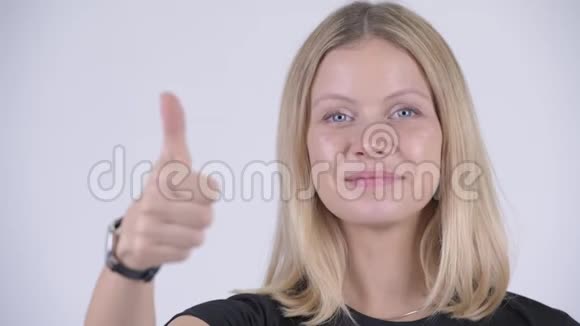年轻快乐的金发女人竖起大拇指的脸视频的预览图