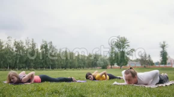 三位年轻模特在公园练习瑜伽视频的预览图