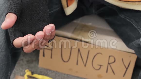 无家可归的人伸出颤抖的手乞讨贫穷和痛苦视频的预览图