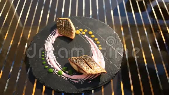 厨师长用钳子装饰一盘高级菜肴特写镜头小土豆鱼骡子视频的预览图