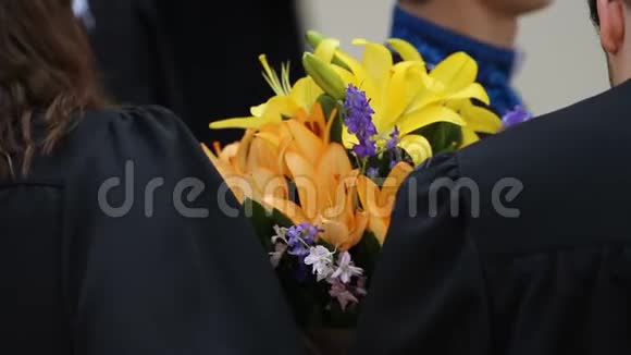 快乐的学生捧着鲜花祝贺毕业视频的预览图