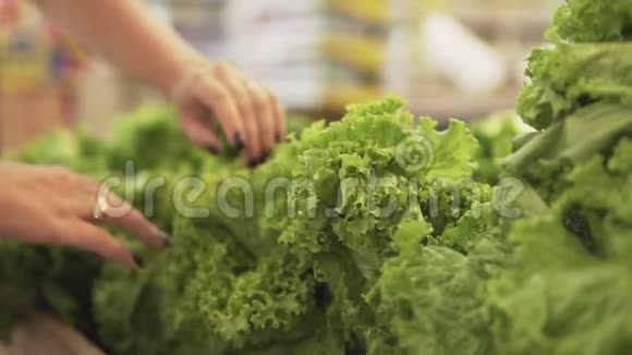 年轻漂亮的女人在超市买新鲜健康的沙拉和蔬菜给家人选择手臂视频的预览图