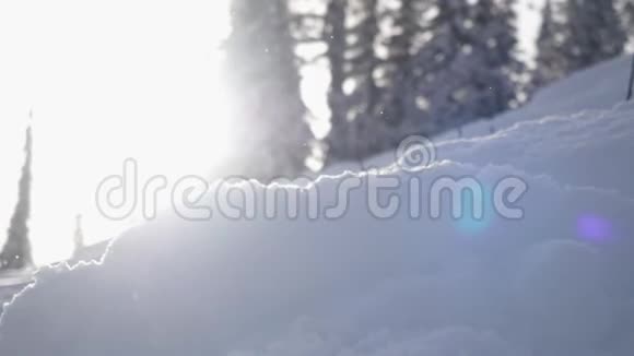 令人惊叹的冬季景观与高刺和漂移雪镜头耀斑效应在降雪期间的山脉慢慢慢慢视频的预览图