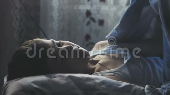 男孩晚上睡在卧室的床上上面盖着一条毯子视频的预览图